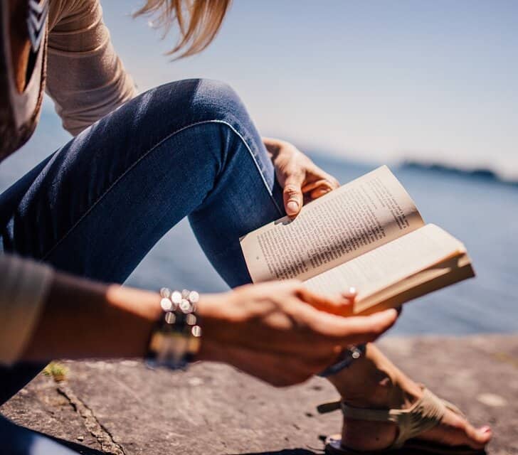 woman reading book outside