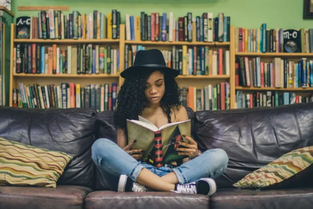 woman reading book on couch